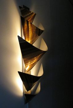 a wall mounted sculpture with three lights on it