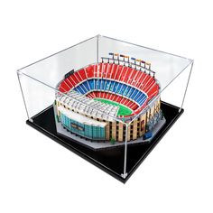 a model of a stadium with red and blue seats on the sides, in a clear acrylic case