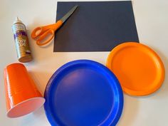 the supplies needed to make an orange and blue frisbee craft are shown here