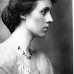 an old black and white photo of a woman with a necklace on her neck, looking to the side