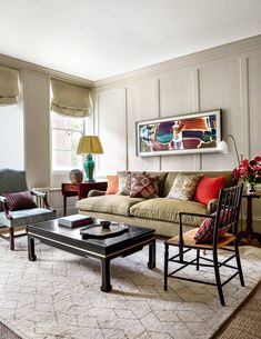 a living room filled with furniture and a coffee table in front of a large window