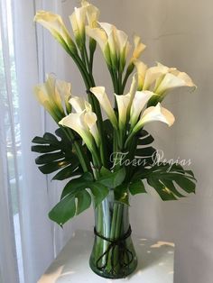 white flowers in a green vase on a table