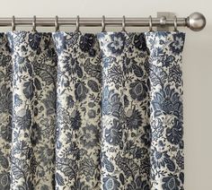 blue and white floral curtains hanging on a curtain rod