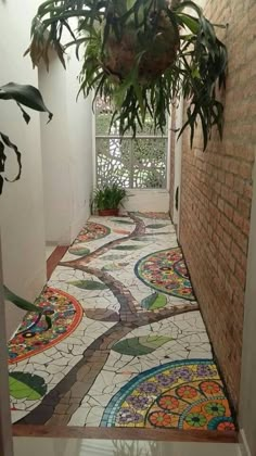 a hallway with colorful tiles on the floor and potted plants