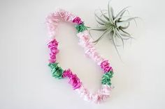 an air plant sitting on top of a table next to some pink and green flowers