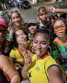 a group of young people with face paint on their faces posing for a photo together