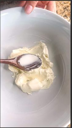 a spoon in a white bowl filled with whipped cream