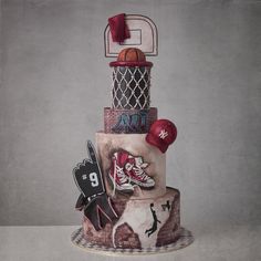 a three tiered cake with sports related items on it and an air jordan hat