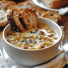 a bowl of soup with bread on the side