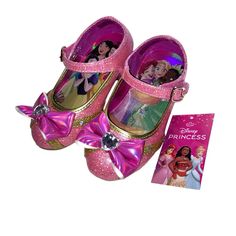 a pair of pink princess shoes next to a card