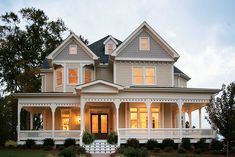 a large white house sitting on top of a lush green field