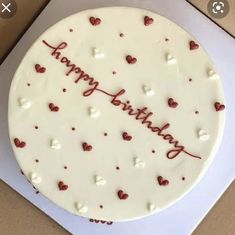 a white cake with red hearts on it