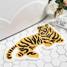 a tiger rug sitting on the floor next to a bath tub