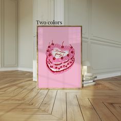 a pink birthday cake with two colors on it in front of a white wall and wooden floor