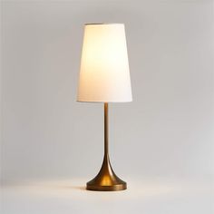 a lamp that is on top of a white surface with a light bulb in the middle