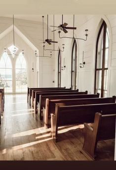 an empty church with wooden pews and stained glass windows