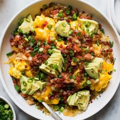 a white bowl filled with eggs, avocado and other toppings on top of a table