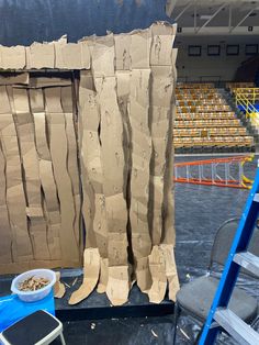 some cardboard is sitting on the ground in front of an empty stadium bleachers