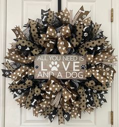 a wreath that says, all you need is love and a dog on the front door