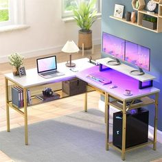 a computer desk with two monitors and a laptop on it in front of a blue wall