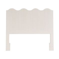 a white headboard with scalloped edges on an isolated white background, viewed from the side