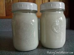 two jars with white frosting sitting on a counter