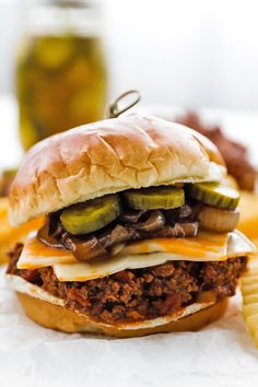 a sloppy joe sandwich with pickles and cheese