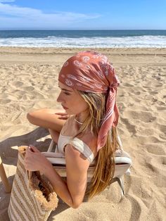 a woman sitting in a chair on the beach