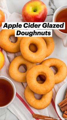 apples, cinnamon sticks and apple cider on a marble table top with two cups of tea