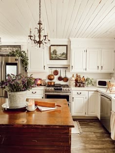 a kitchen filled with lots of white cupboards and counter top next to a stove top oven