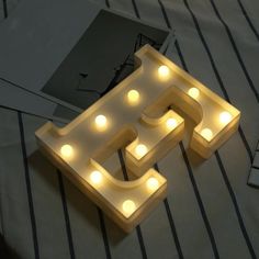 a light up letter that is sitting on a bed