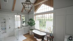 a bathroom with a large tub and wooden floors