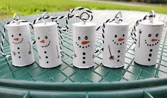 four toilet paper roll snowmen sitting on top of a green table