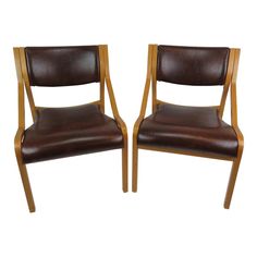 a pair of brown leather chairs with wooden frame and back rests against each other on a white background