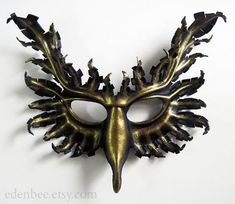 This wearable griffin mask has been hand-molded from high quality vegetable tanned cow leather, from a template of my own design. It has been hand-painted with acrylic paint, inside and out, in black, with metallic light gold highlights.The mask is sturdy, but also lightweight and flexible and comfortable to wear. It comes with two removable ties attached. Great for use as part of a costume, or for display on the wall. The size of the piece is approximately 11" wide by 9" tall. The fourth photo Shape Templates, Leather Mask, Hand Molding, Costume Masks, Marriott Hotels, Gold Highlights, Costume Mask, The Mask, Black Bird