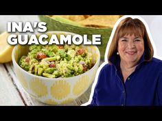 a woman standing next to a bowl filled with guacamole