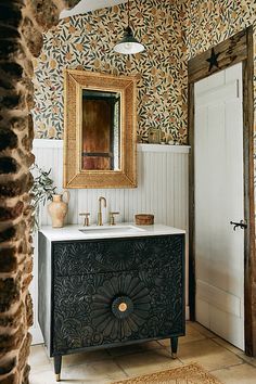 a bathroom vanity with a mirror above it and a vase on the counter next to it