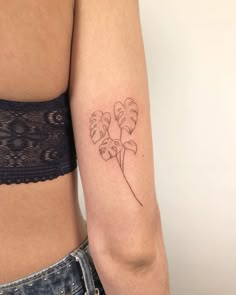 a woman with a tattoo on her arm has a flower in the shape of a heart