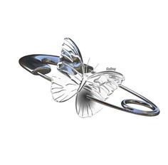 a butterfly shaped brooch sitting on top of a piece of plastic material in the air