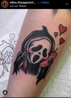 a girl with a skull on her arm holding a knife and heart shaped candy bar