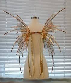 a white mannequin with gold wings on it