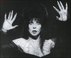 a black and white photo of a woman with her hands in the air