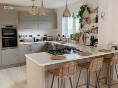 a kitchen with an island and three stools in front of the stove top oven