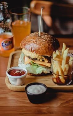 a cheeseburger with fries and ketchup on a wooden tray at a restaurant