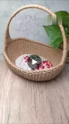 a wicker basket sitting on top of a wooden floor next to a potted plant