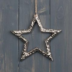 a metal star hanging on a wooden wall