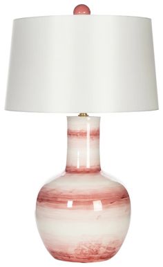 a red and white lamp with a white shade on it's base is sitting in front of a white background