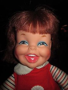 an old doll with red hair and blue eyes