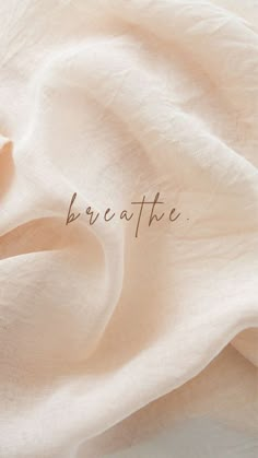 the words breathe are written in cursive handwriting on a white sheet that is draped over it