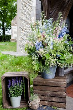 two wooden crates with flowers in them on the ground